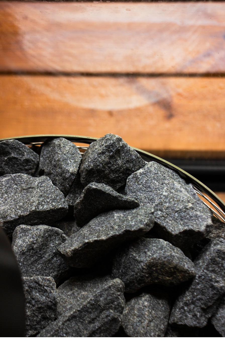 Finnish granite stones arranged in the IKI heater basket for authentic löyly steam