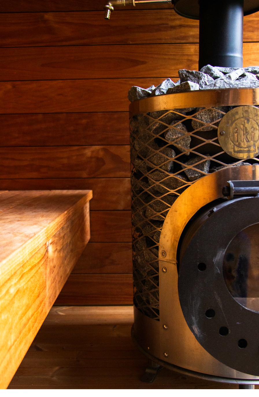 iHKA sauna interior showing warm Finnish wood paneling and IKI heater