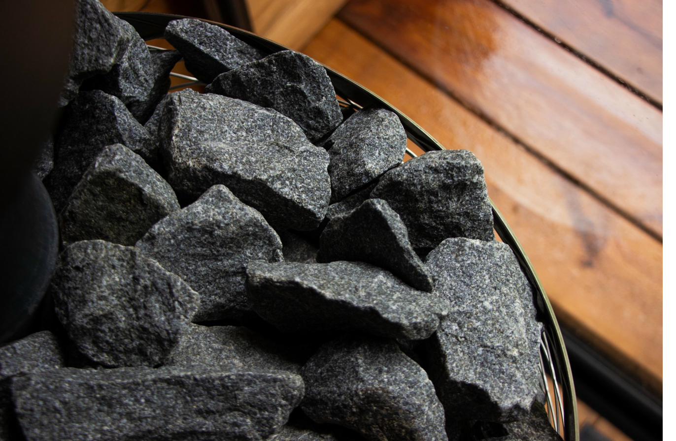 Sauna stones in IKI heater basket with Finnish wood wall paneling